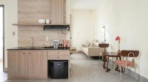 a kitchen and living room with a table and a couch at Chăm Charm Mũi Né, Phan Thiết in Mui Ne