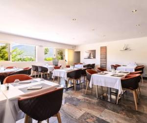a restaurant with white tables and chairs and windows at Cottage PARKS ESCAPADE COLOMBA in Olmeto
