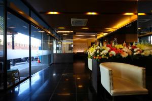 a lobby with a waiting area with flowers and a chair at Hotel M Chiang Mai in Chiang Mai
