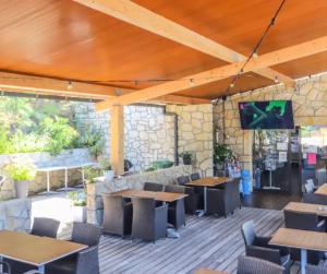 a restaurant with tables and chairs and a tv on a wall at Cottage PARKS ESCAPADE COLOMBA in Olmeto