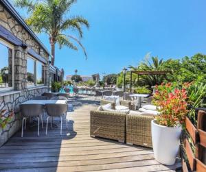 a deck with tables and chairs on a resort at Cottage PARKS ESCAPADE COLOMBA in Olmeto