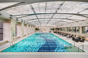a large indoor swimming pool with blue water at The Imperial Mansion, Beijing - Marriott Executive Apartments in Beijing