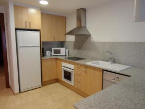 una cucina con frigorifero bianco e lavandino di Apartaments Bonaventura 24 a Sitges