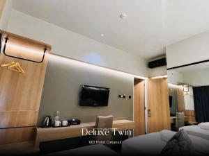a hotel room with a television and a bed at Vio Hotel Cimanuk Bandung in Bandung