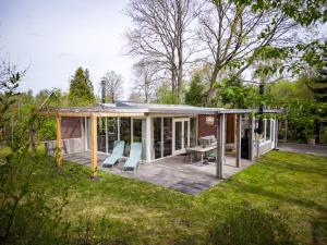 a small house with a deck and a patio at Kamille | 4 persons in Gasselte