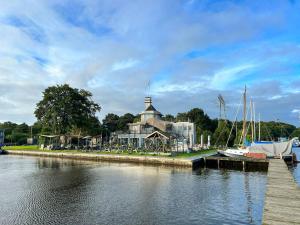 a building next to a river with boats in the water at Summio Waterpark De Bloemert in Zuidlaren +3 photos