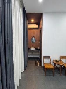 a hallway with white curtains and a table and a sink at Charm House Hue in Hue