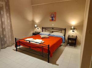 a bedroom with a bed with an orange blanket at Alexia Ferentinou in Fiskardo