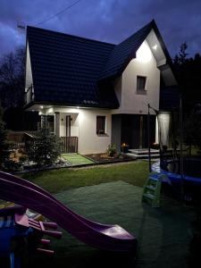 a house with a slide and a playground in the yard at Domek Sołtysówka Balia&Sauna in Gliczarów Górny