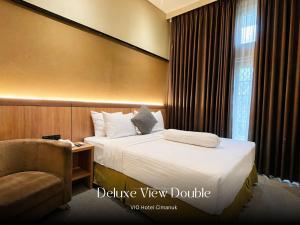 a hotel room with a bed and a chair at Vio Hotel Cimanuk Bandung in Bandung +27 photos
