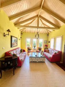 a large living room with red couches and a table at Villa AVRA in Drama