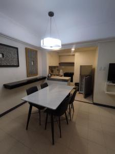 a dining room with a table and chairs and a kitchen at Ralph Anthony Suites Hotel in Manila +8 photos