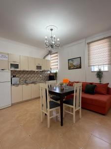 a living room with a table and a red couch at Valentino Apartments in Shkodër