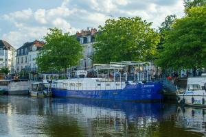 a blue and white boat is docked in the water at Le Petit Talensac in Nantes