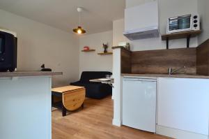 a kitchen and living room with a couch and a microwave at Le Petit Talensac in Nantes