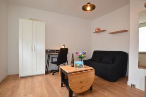 a living room with a black couch and a desk at Le Petit Talensac in Nantes