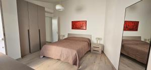 a bedroom with a bed and a mirror at Blue Living -Archi di Mare in Marciana Marina