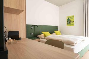ein Hotelzimmer mit zwei Betten und gelben Kissen in der Unterkunft eee Hotel Laakirchen in Laakirchen