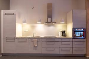a kitchen with white cabinets and a sink and a refrigerator at Sallainen Panvillage in Salla +9 photos