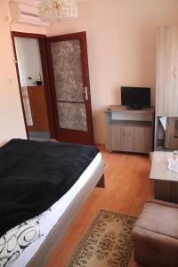 a bedroom with a bed and a desk with a television at Diófa Vendégház in Bükkszék