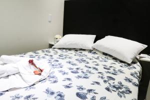 a bedroom with a bed with blue and white sheets and pillows at Pousada Flor Dália in Natal