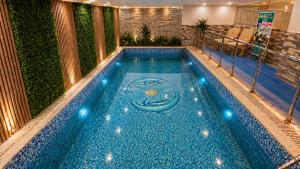 a swimming pool with a painting on the side of a building at Vantara Premium, Haridwar- with swimming Pool in Haridwār