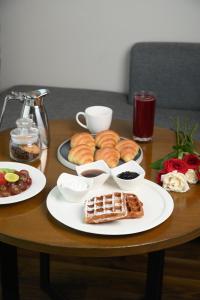 a table with plates of pastries and other food on it at Courtyard by Marriott Gurugram Downtown in Gurgaon