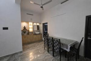 a dining room with a table and chairs and a kitchen at The VARKALA HAVEN 105 in Varkala