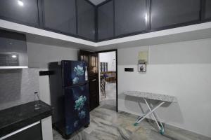 a kitchen with a black refrigerator and a table at The VARKALA HAVEN 105 in Varkala +5 photos