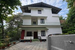 a white house with a black roof at The VARKALA HAVEN 105 in Varkala