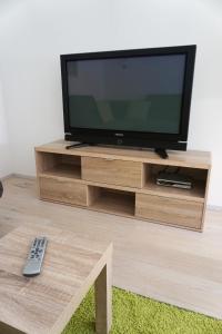 a flat screen tv on a wooden entertainment center at Appart Rosa in Pfunds