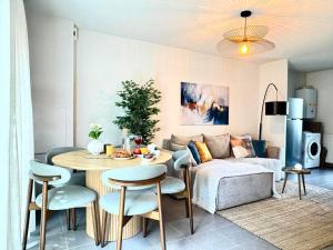 a living room with a table and a couch at Charming Tournefeuille House in Tournefeuille