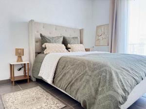 a bedroom with a large bed with a gray comforter at Charming Tournefeuille House in Tournefeuille