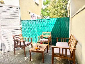three chairs and a table on a patio at Charming Tournefeuille House in Tournefeuille