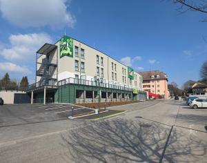 ein großes Gebäude an einer Straße mit Parkplatz in der Unterkunft eee Hotel Laakirchen in Laakirchen