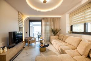 a living room with a couch and a tv at The Four Villas Hanioti by Luxlikehome in Hanioti