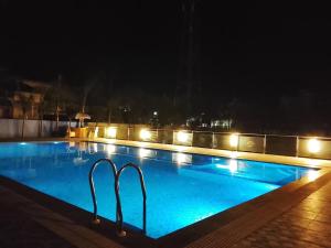 a swimming pool at night with lights at Bodhgaya Regency Hotel in Bodh Gaya +63 photos