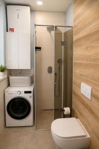 a bathroom with a washing machine and a shower at Urban Getaway Sarajevo with Free Parking in Sarajevo +24 photos