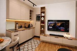 a kitchen with a flat screen tv on a wall at Urban Getaway Sarajevo with Free Parking in Sarajevo