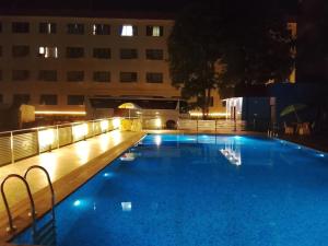 a large blue swimming pool at night with a building at Bodhgaya Regency Hotel in Bodh Gaya