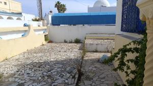 a stone walkway in front of a building at Charmante maison plage in Soliman