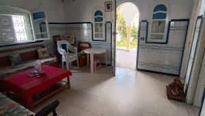 a living room with a couch and a table at Charmante maison plage in Soliman