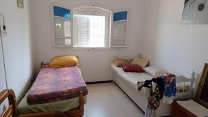 a small room with two beds and a window at Charmante maison plage in Soliman