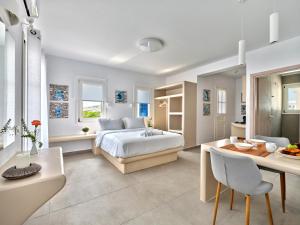 a white bedroom with a bed and a table at Bedspot Apartments Paros in Naousa