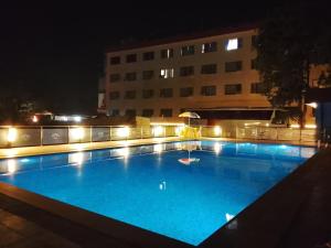 a large swimming pool at night with a building at Bodhgaya Regency Hotel in Bodh Gaya