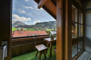 ein Balkon mit Tisch und Blick auf die Berge in der Unterkunft Ferienwohnung Edelweiß mit Sommer- Bergbahn unlimited kostenlos in Obermaiselstein