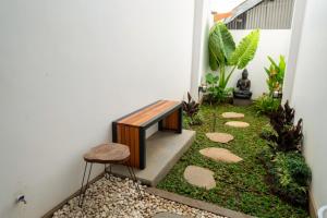 a garden in the corner of a house with a bench at Gumitish Residence Singaraja in Singaraja