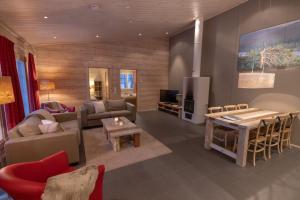 a living room with a couch and a table and chairs at Sallainen Panvillage in Salla