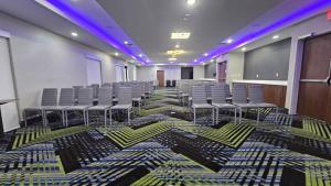 a room with chairs and a stage with purple lights at Holiday Inn Express & Suites Kansas City - Oak Grove I-70 by IHG in Oak Grove +23 photos