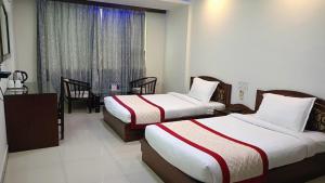 a hotel room with two beds and a dining room at Bodhgaya Regency Hotel in Bodh Gaya